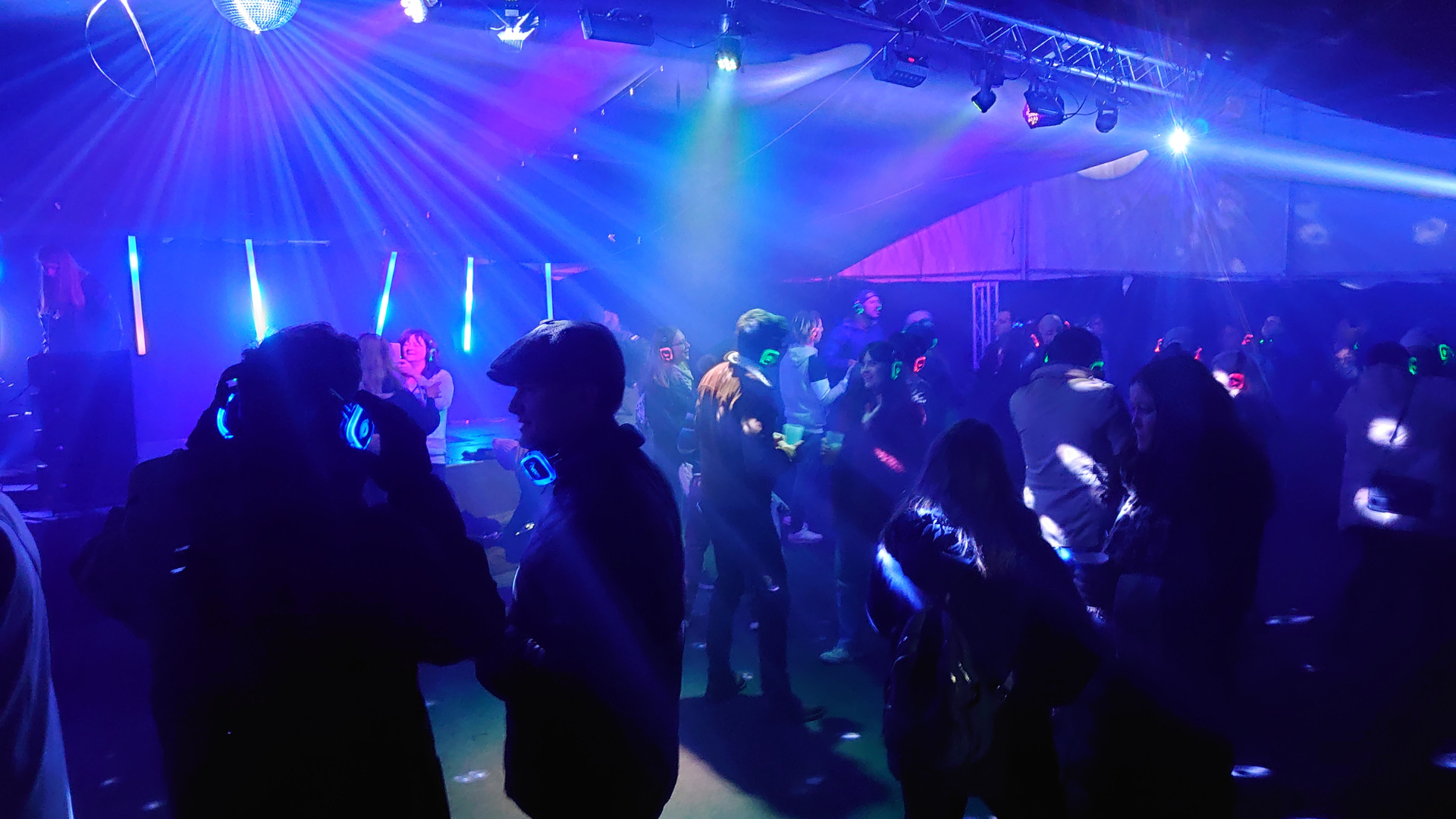 People listening to a silent disco in outdoor marquee